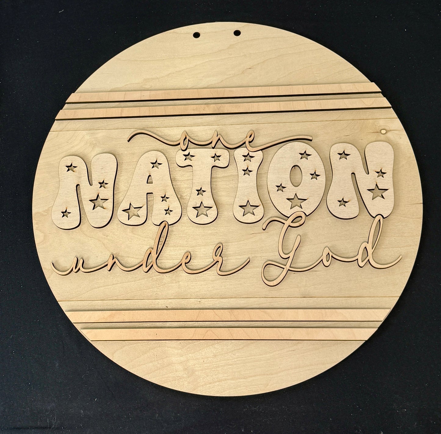 Round wooden sign with 'Nation Under God' engraving on a black background